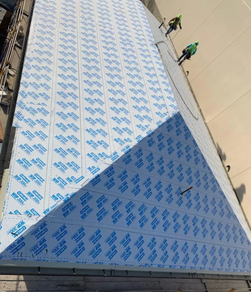 Professional roofers installing underlayment on a metal roof in Stallings